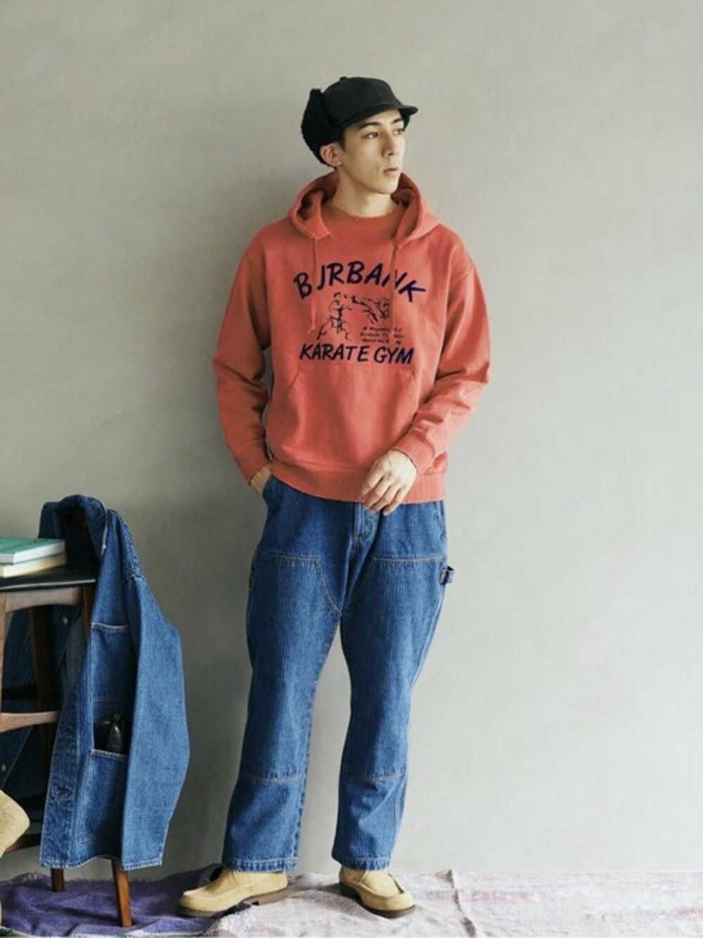 レッド系のパーカー、ブルー系のデニムパンツを着用したメンズの冬コーディネートの1枚目の写真