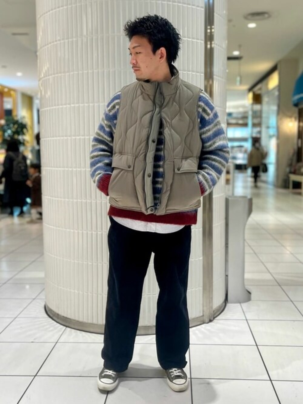 グリーン系のその他アウター、ブルー系のニット/セーター、ブラック系のスラックスを着用したメンズの冬コーディネートの1枚目の写真