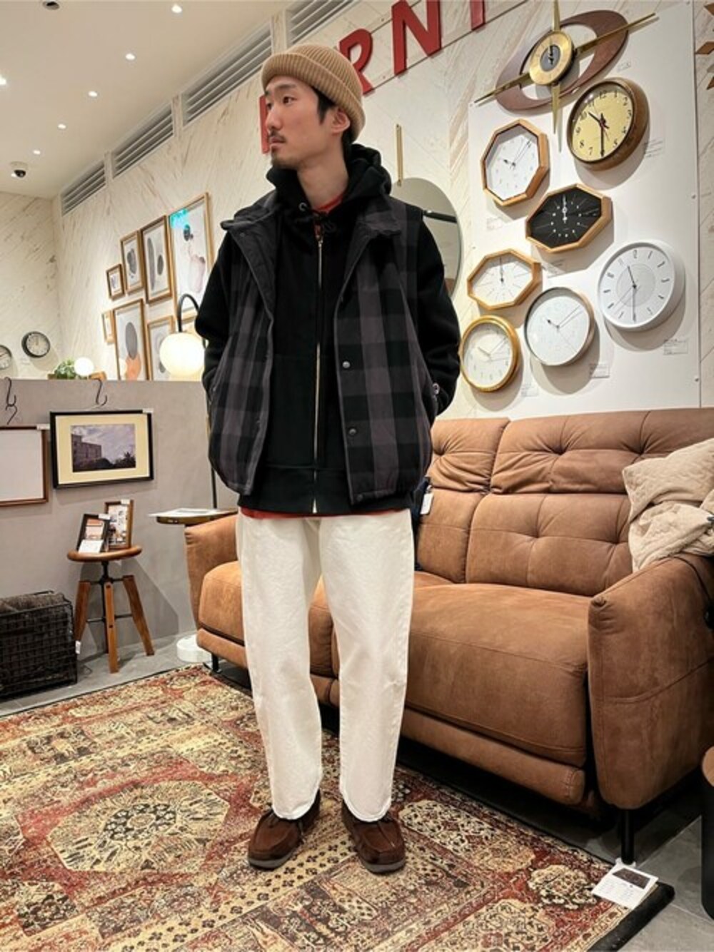 ブラック系のベスト、オレンジ系のTシャツ/カットソー、ホワイト系のデニムパンツを着用したメンズの冬コーディネートの1枚目の写真