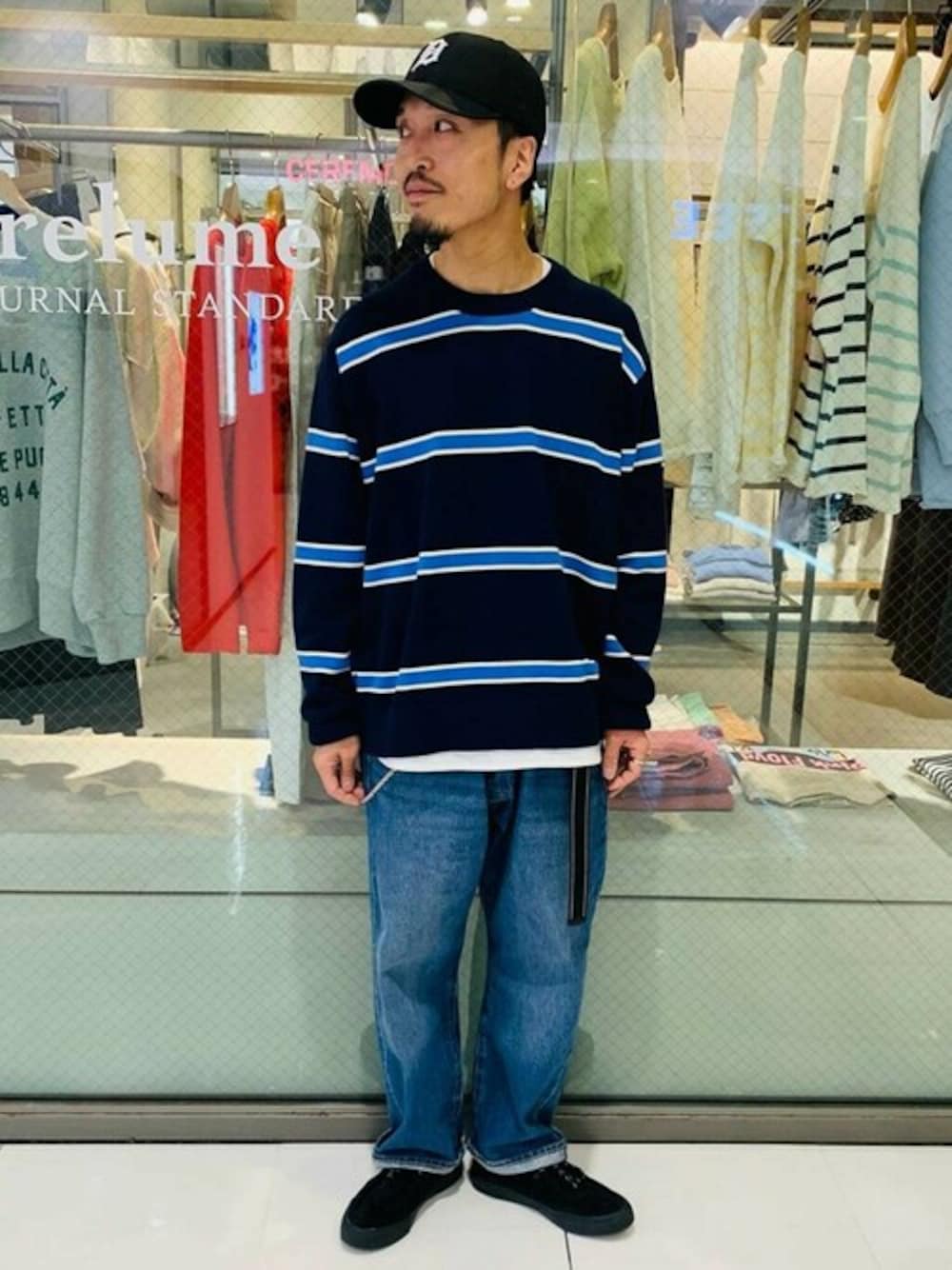 ブルー系のニット/セーター、ブルー系のデニムパンツ、ブラック系のスニーカーを着用したメンズの冬コーディネートの1枚目の写真