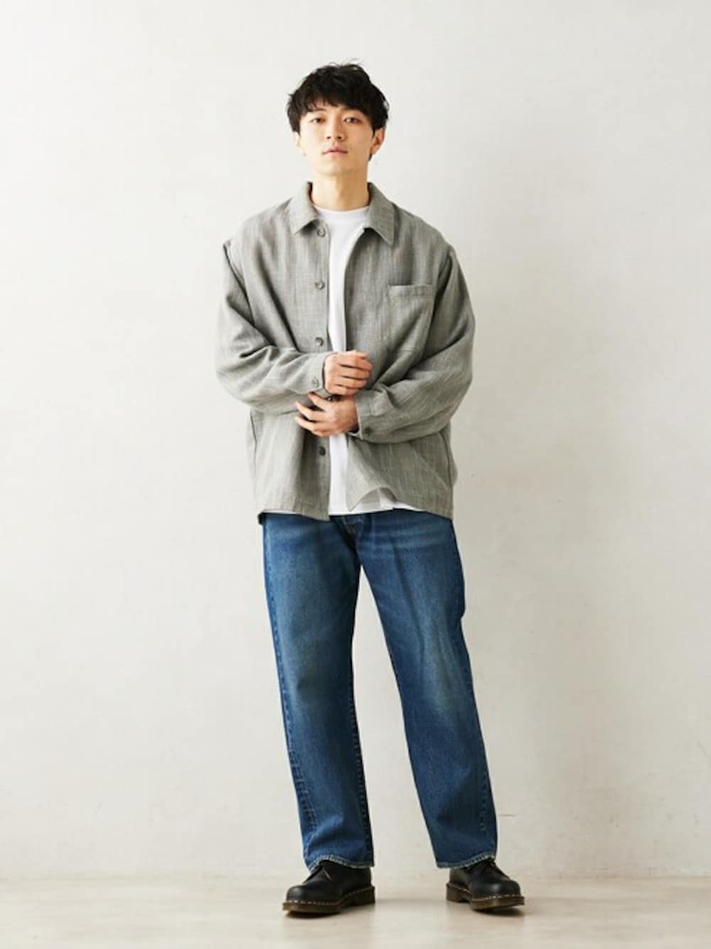 グレー系のその他アウター、ブルー系のデニムパンツを着用したメンズの冬コーディネートの1枚目の写真