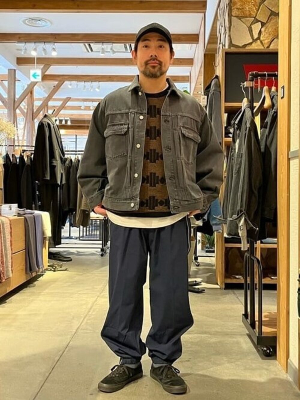 ブラック系のデニムジャケット、ブラック系のニット/セーター、ブルー系のその他パンツを着用したメンズの冬コーディネートの1枚目の写真