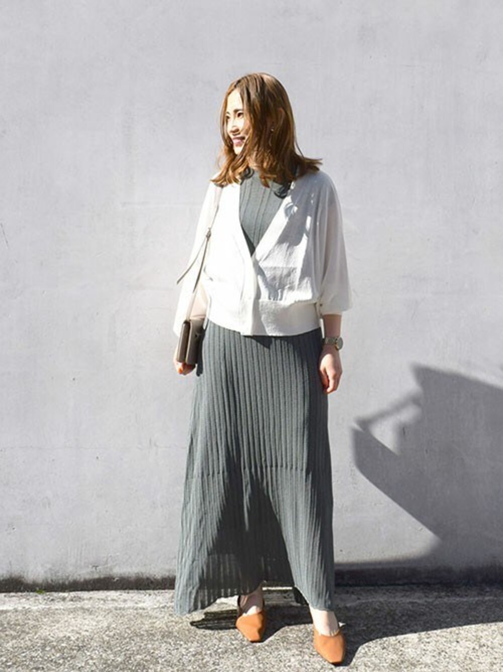 ホワイト系のカーディガン/ボレロ、グリーン系のニット/セーター、グリーン系のスカートを着用したレディースの春コーディネートの1枚目の写真