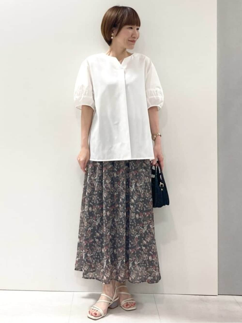 ホワイト系のシャツ/ブラウス、グレー系のスカートを着用したレディースの夏コーディネートの1枚目の写真