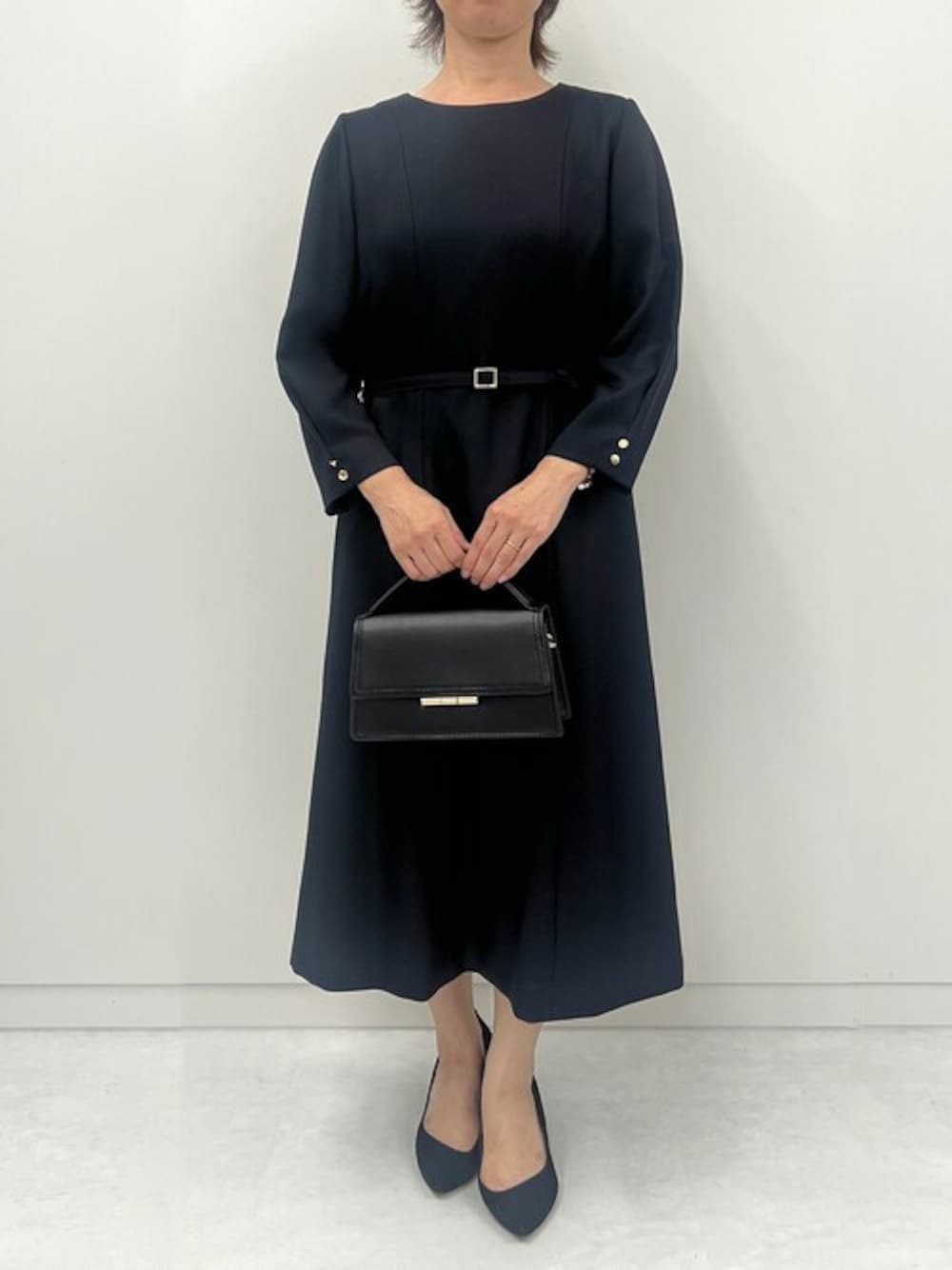 ブルー系のワンピースを着用したレディースの秋コーディネートの1枚目の写真