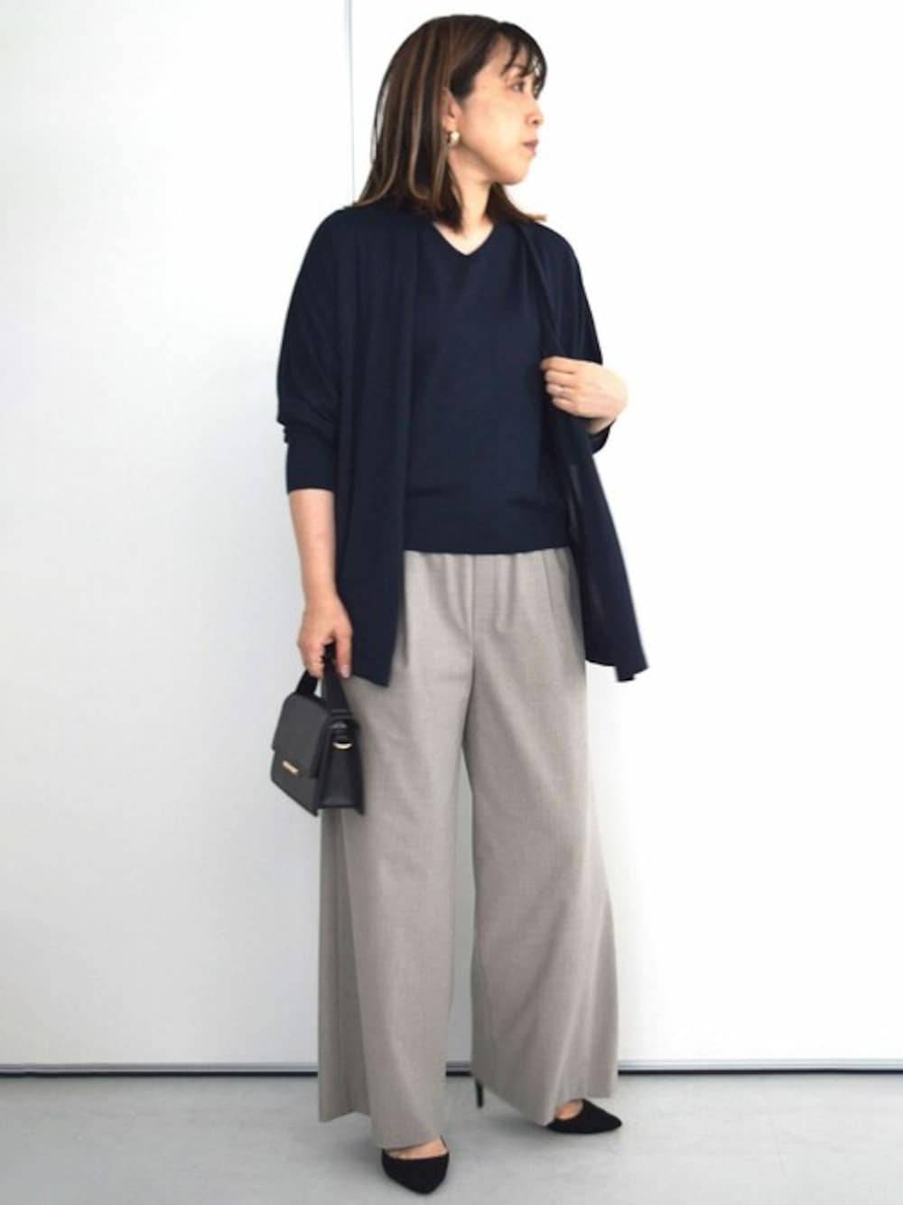 ブルー系のアンサンブル、ベージュ系のその他パンツを着用したレディースの秋コーディネートの1枚目の写真