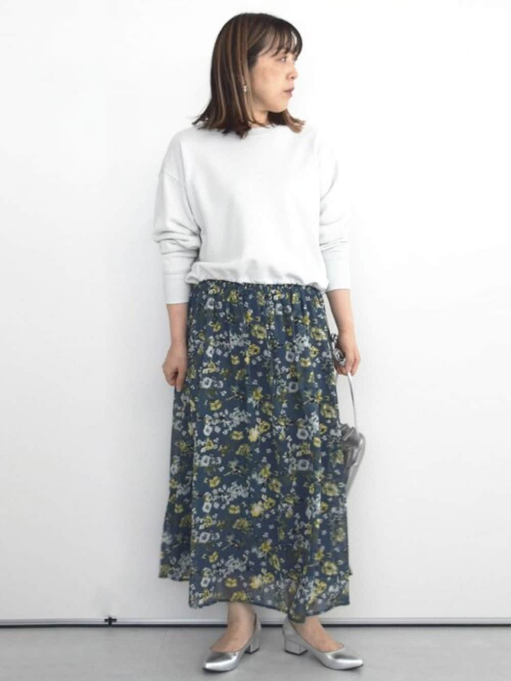 グレー系のスウェット、ブルー系のスカートを着用したレディースの秋コーディネートの1枚目の写真