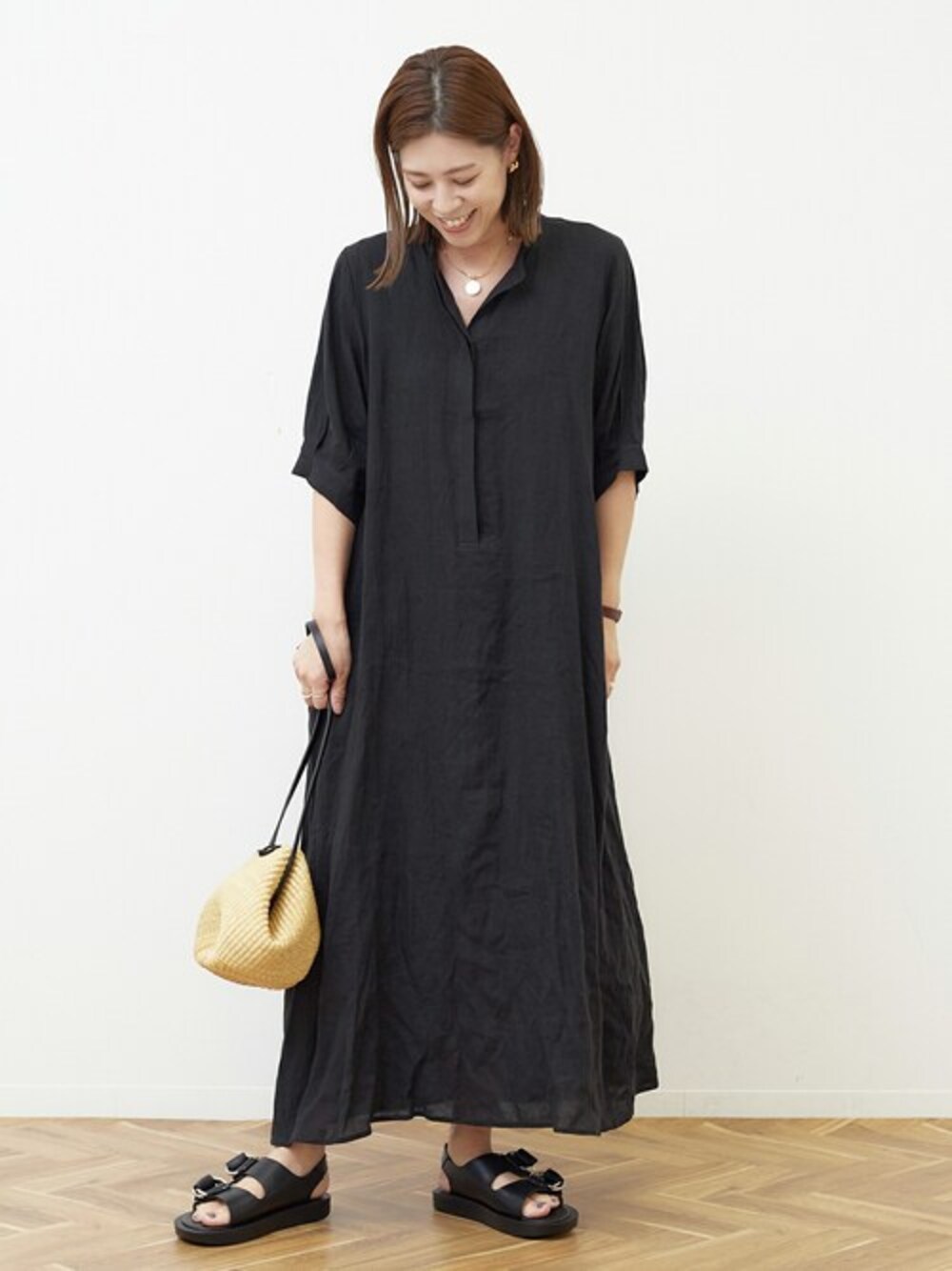 ブラック系のワンピースを着用したレディースの春コーディネートの1枚目の写真