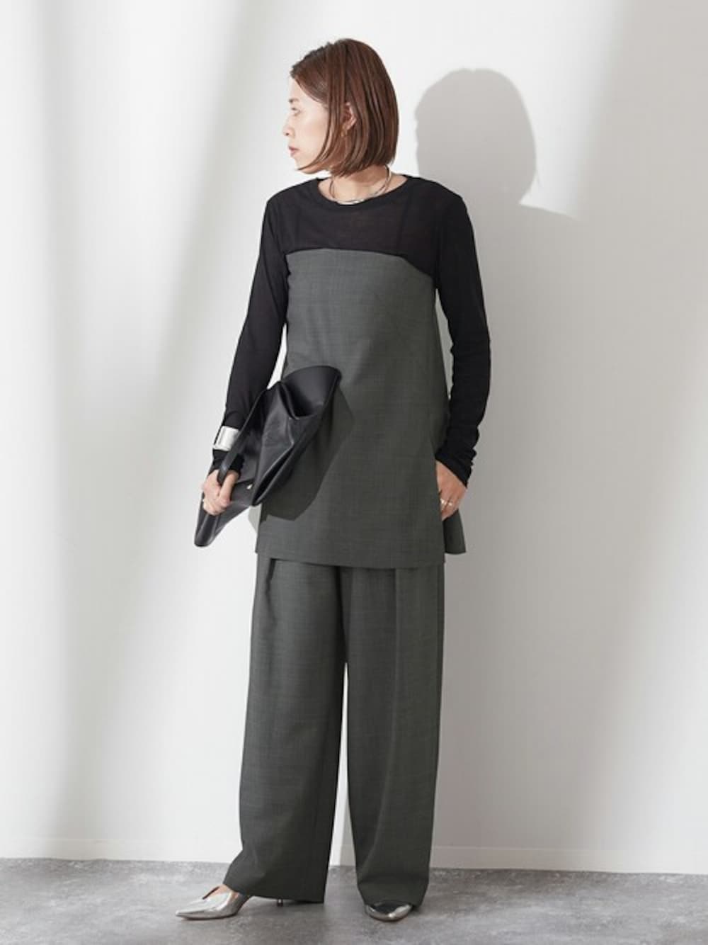 グレー系のスラックスを着用したレディースの夏コーディネートの1枚目の写真