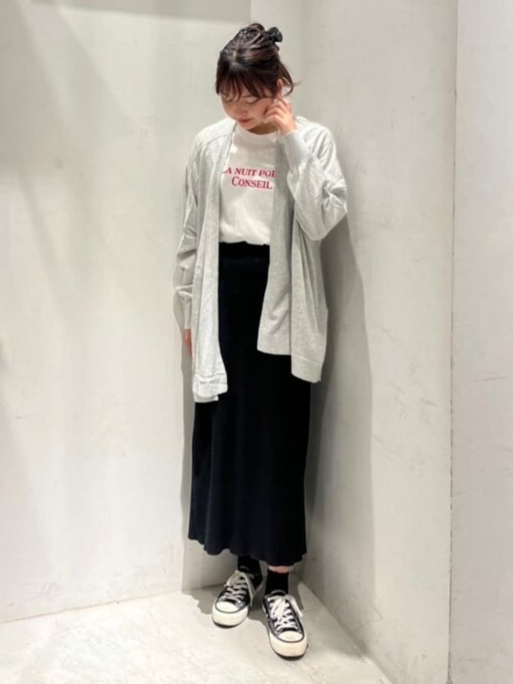 レッド系のTシャツ/カットソー、グレー系のカーディガン/ボレロ、ブラック系のスカートを着用したレディースの春コーディネートの1枚目の写真