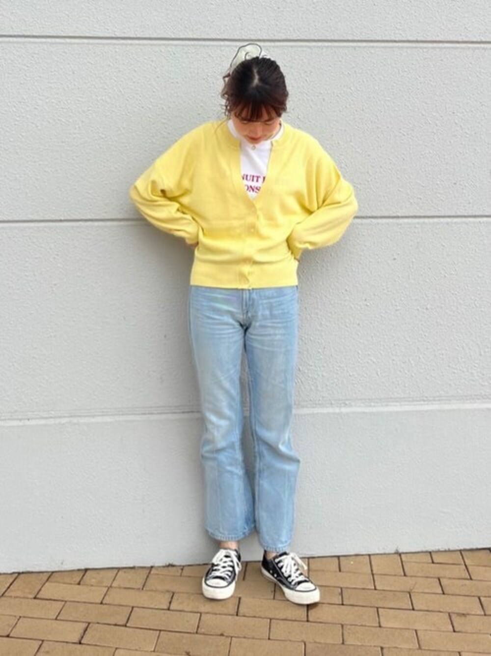 イエロー系のカーディガン/ボレロ、レッド系のTシャツ/カットソー、ブルー系のデニムパンツを着用したレディースの春コーディネートの1枚目の写真