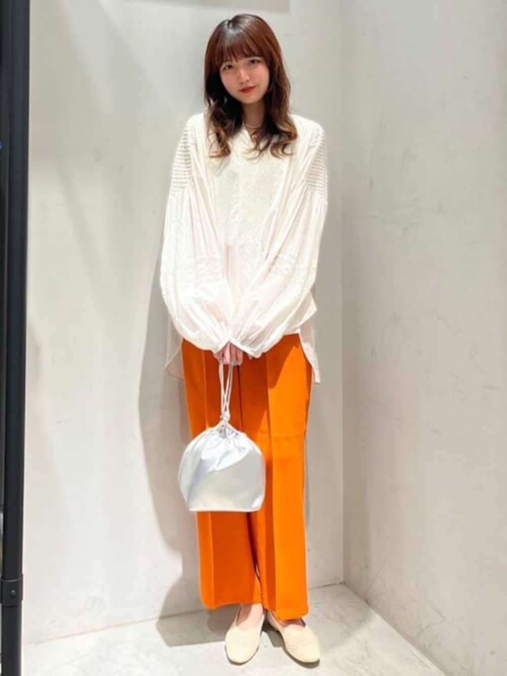 ホワイト系のシャツ/ブラウス、オレンジ系のその他パンツ、シルバー系のエコバッグ/サブバッグを着用したレディースの春コーディネートの1枚目の写真