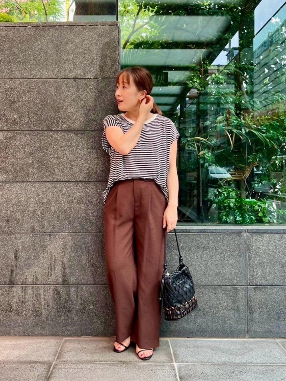 ブラック系のショルダーバッグ、ホワイト系のTシャツ/カットソー、ブラウン系のその他パンツを着用したレディースの夏コーディネートの1枚目の写真