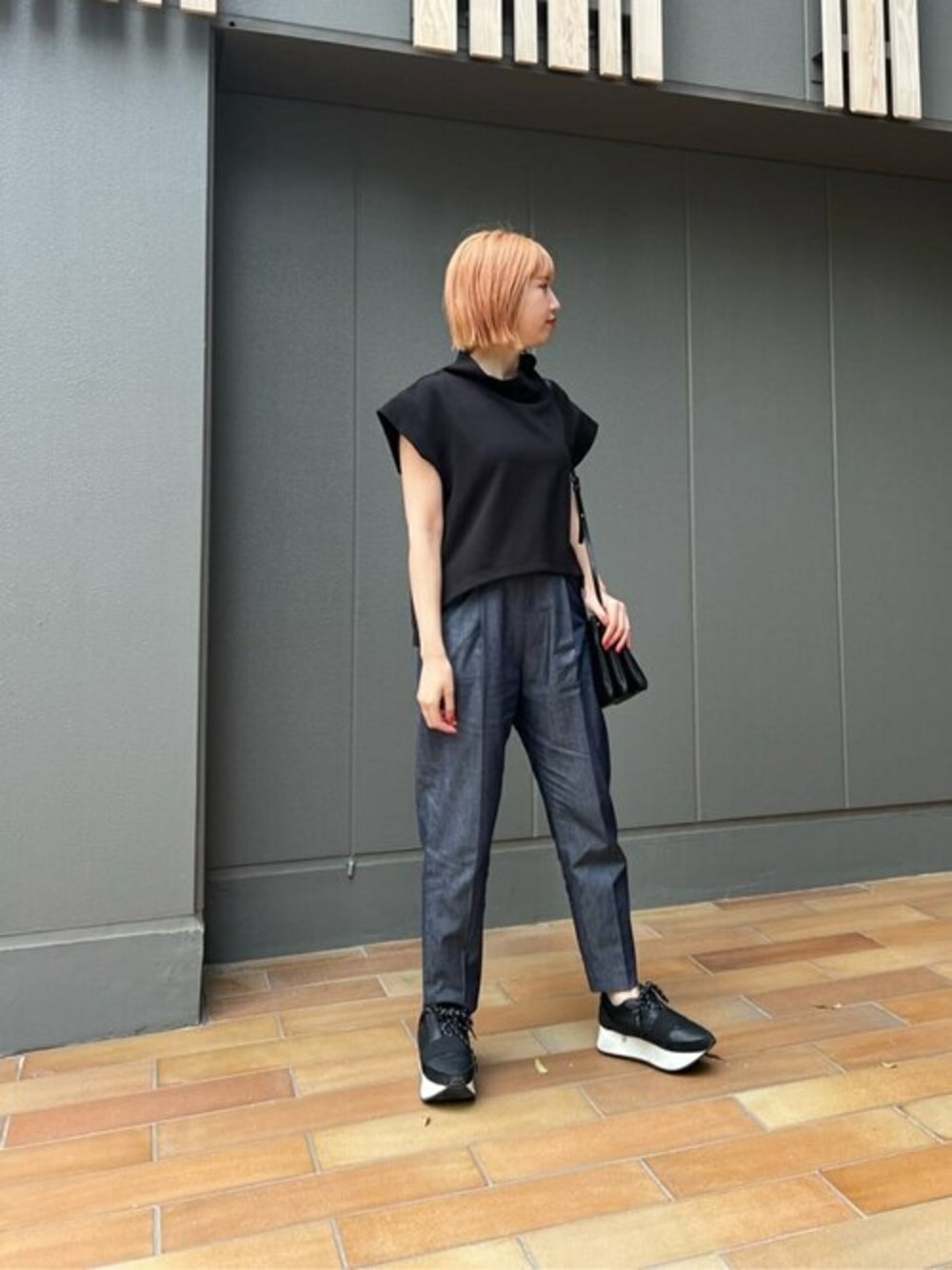 ブルー系のその他パンツ、ブラック系のTシャツ/カットソー、ブラック系のスニーカーを着用したレディースの春コーディネートの1枚目の写真