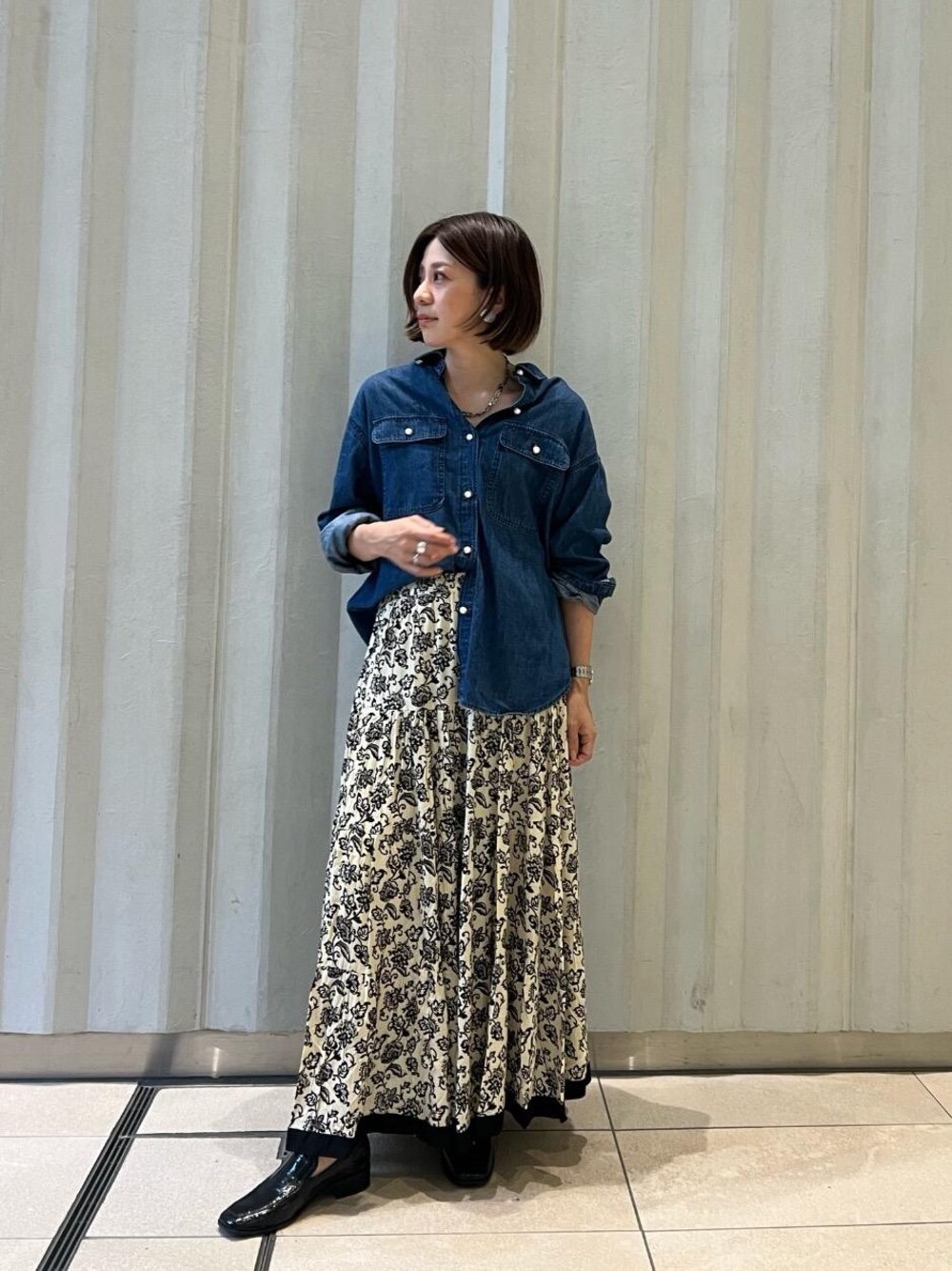 ブルー系のシャツ/ブラウス、ベージュ系のスカートを着用したレディースの秋コーディネートの1枚目の写真