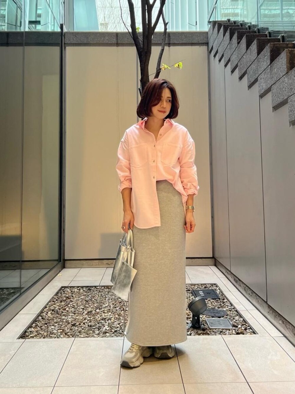 グレー系のスカート、ピンク系のシャツ/ブラウスを着用したレディースの冬コーディネートの1枚目の写真