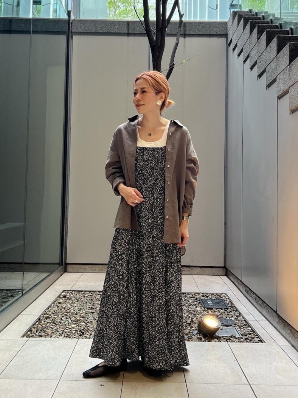 ブラック系のワンピース、ブラウン系のシャツ/ブラウスを着用したレディースの春コーディネートの1枚目の写真