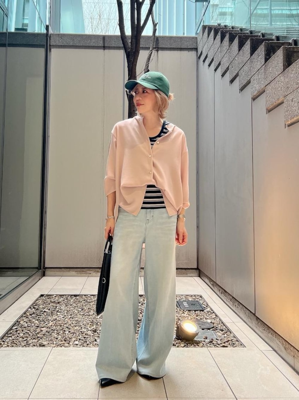 ブルー系のデニムパンツ、ブラック系のパンプス、ピンク系のシャツ/ブラウスを着用したレディースの春コーディネートの1枚目の写真