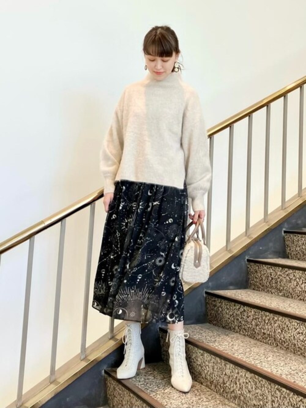 ベージュ系のショルダーバッグ、ブラック系のワンピース、ホワイト系のニット/セーターを着用したレディースの秋コーディネートの1枚目の写真