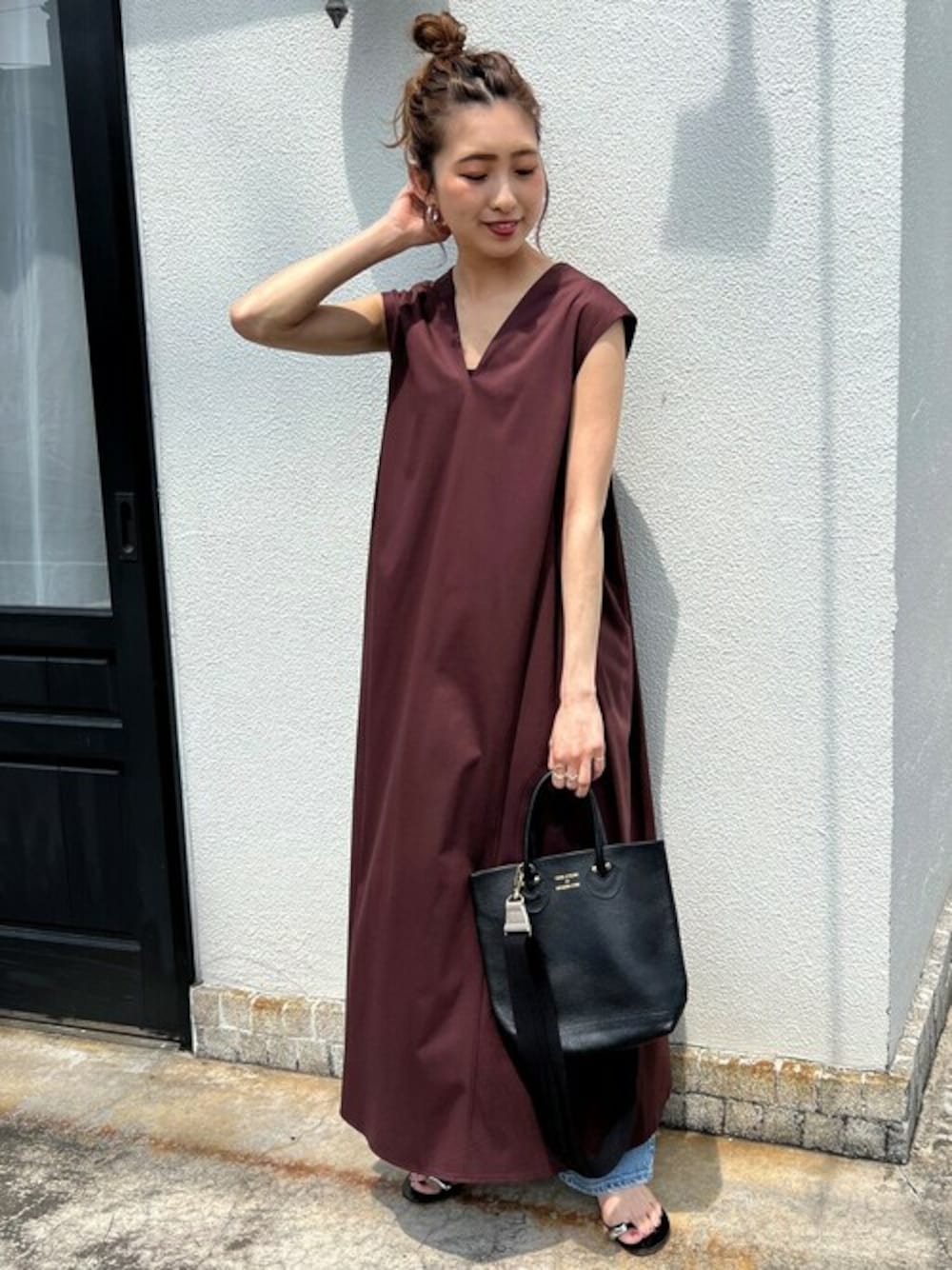 ブラウン系のワンピース、ブルー系のデニムパンツ、ブラック系のサンダルを着用したレディースの夏コーディネートの1枚目の写真