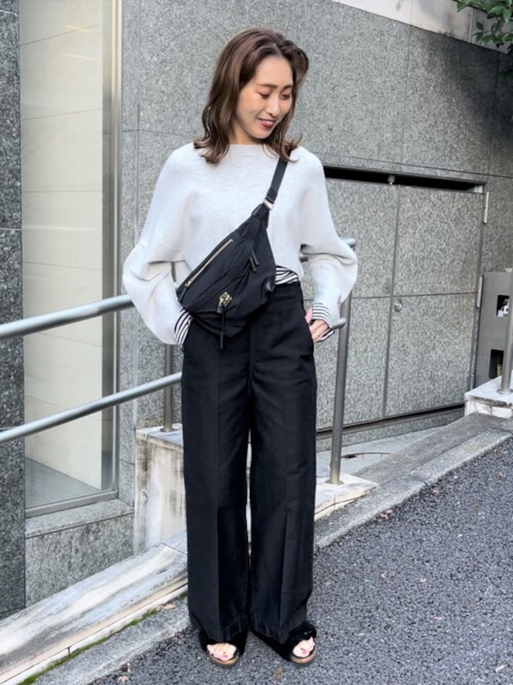 ブラック系のショルダーバッグ、ブラック系のその他パンツ、ブルー系のTシャツ/カットソーを着用したレディースの冬コーディネートの1枚目の写真