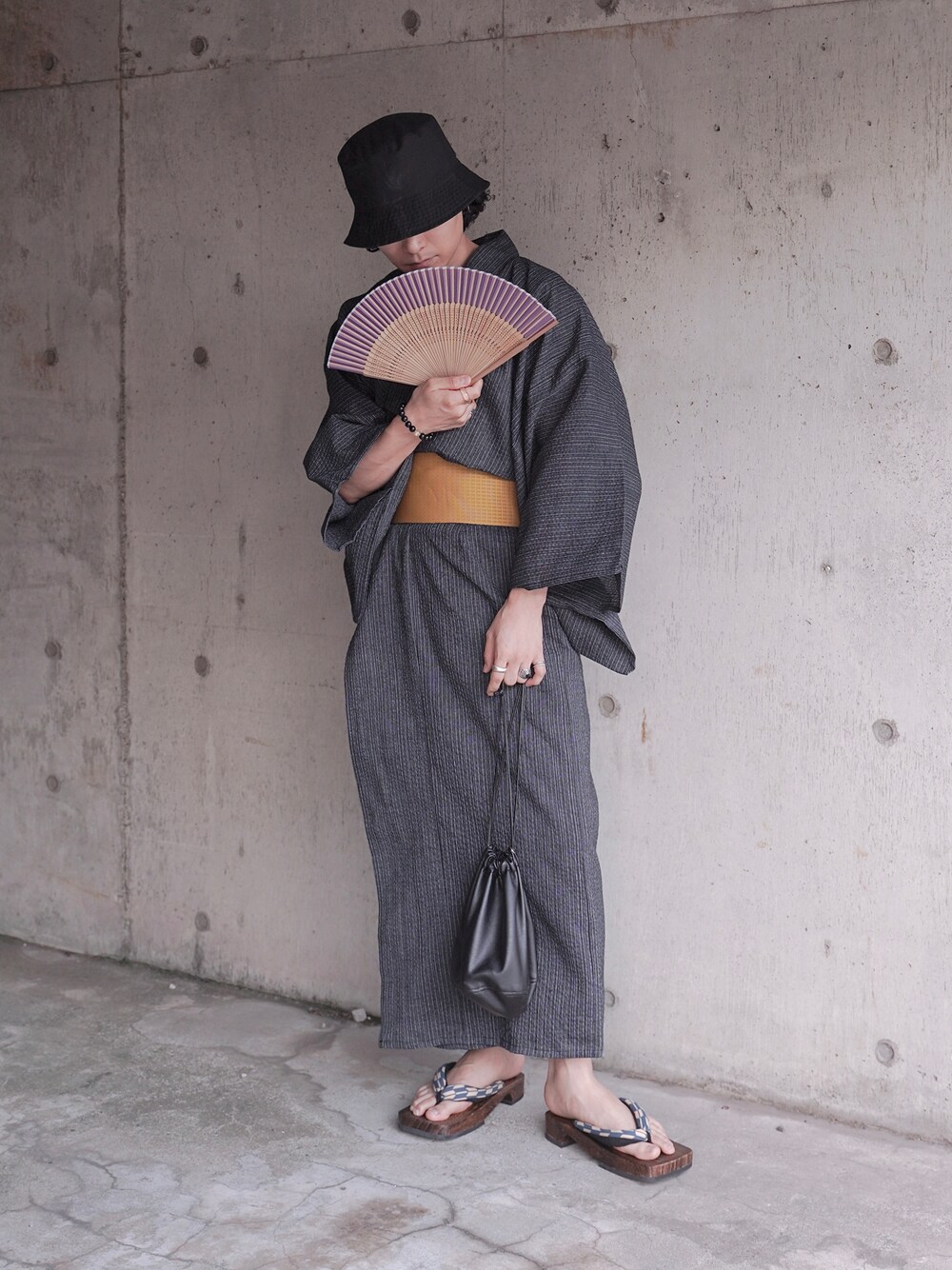 ブラック系のハンドバッグ、ブラック系の浴衣、ブラック系の帽子を着用したメンズの夏コーディネートの1枚目の写真