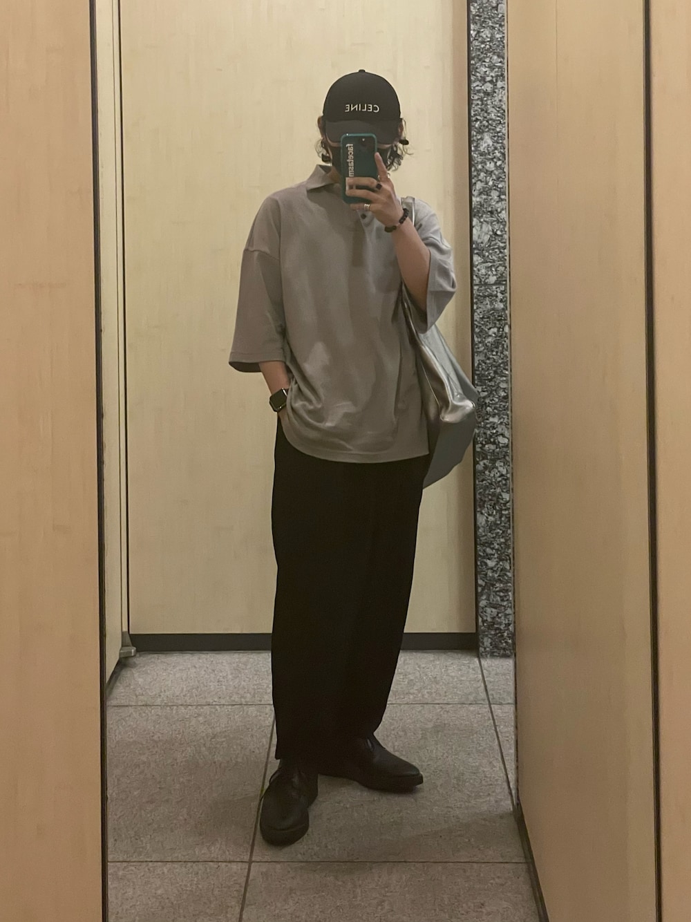 ベージュ系のポロシャツ、シルバー系のトートバッグ、ブラック系のパンツを着用したメンズの夏コーディネートの1枚目の写真