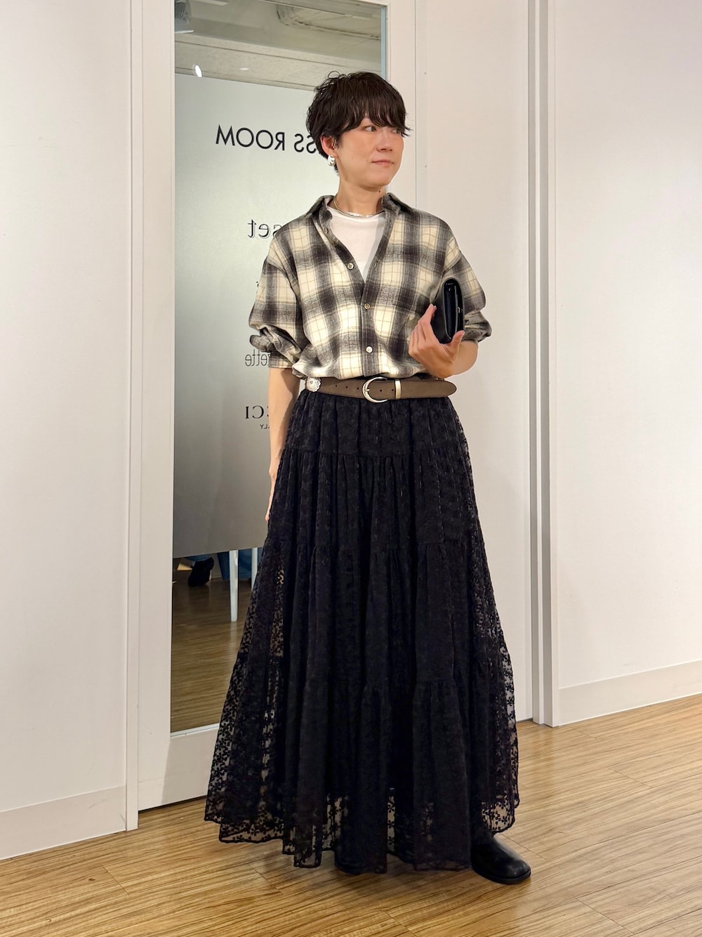 ブラック系のスカート、ベージュ系のシャツ/ブラウス、ホワイト系のTシャツ/カットソーを着用したレディースの秋コーディネートの1枚目の写真