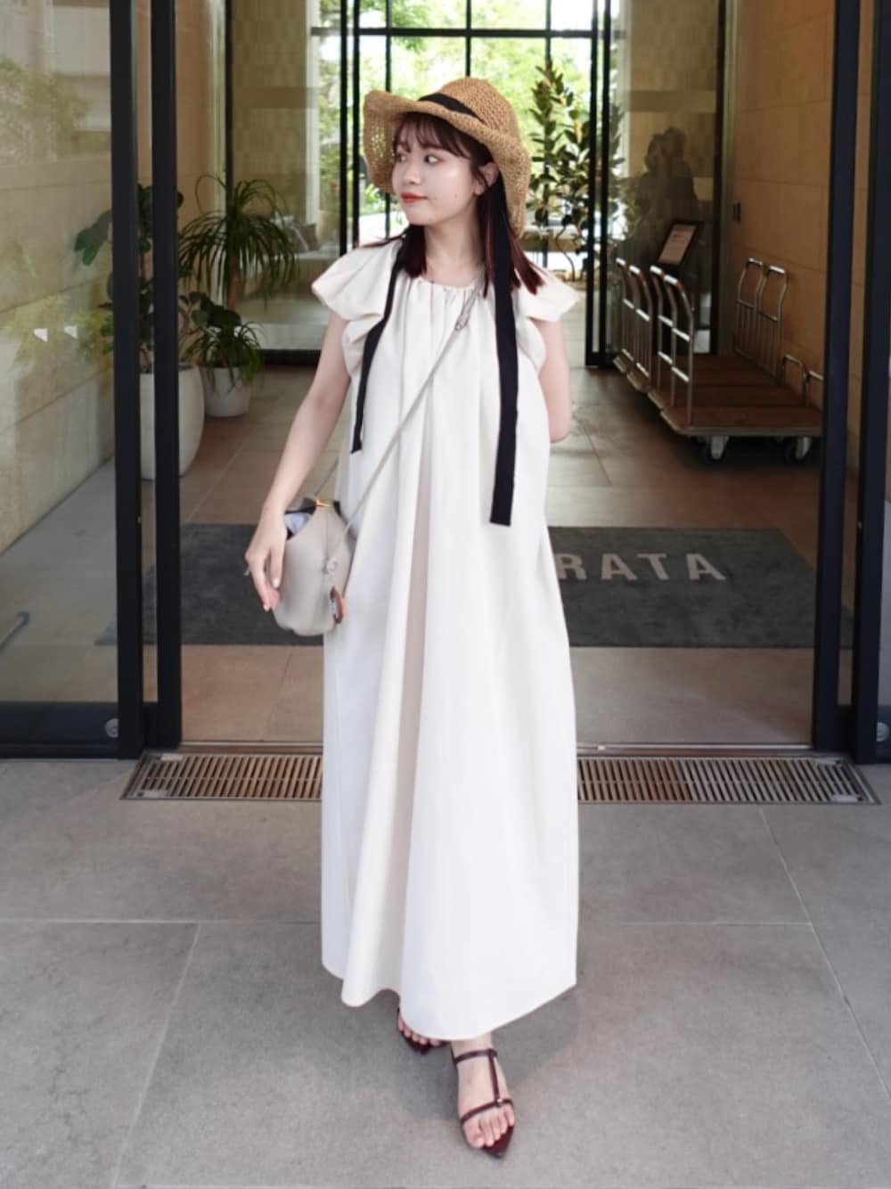 ホワイト系のワンピース、レッド系のサンダル、ベージュ系のショルダーバッグを着用したレディースの夏コーディネートの1枚目の写真