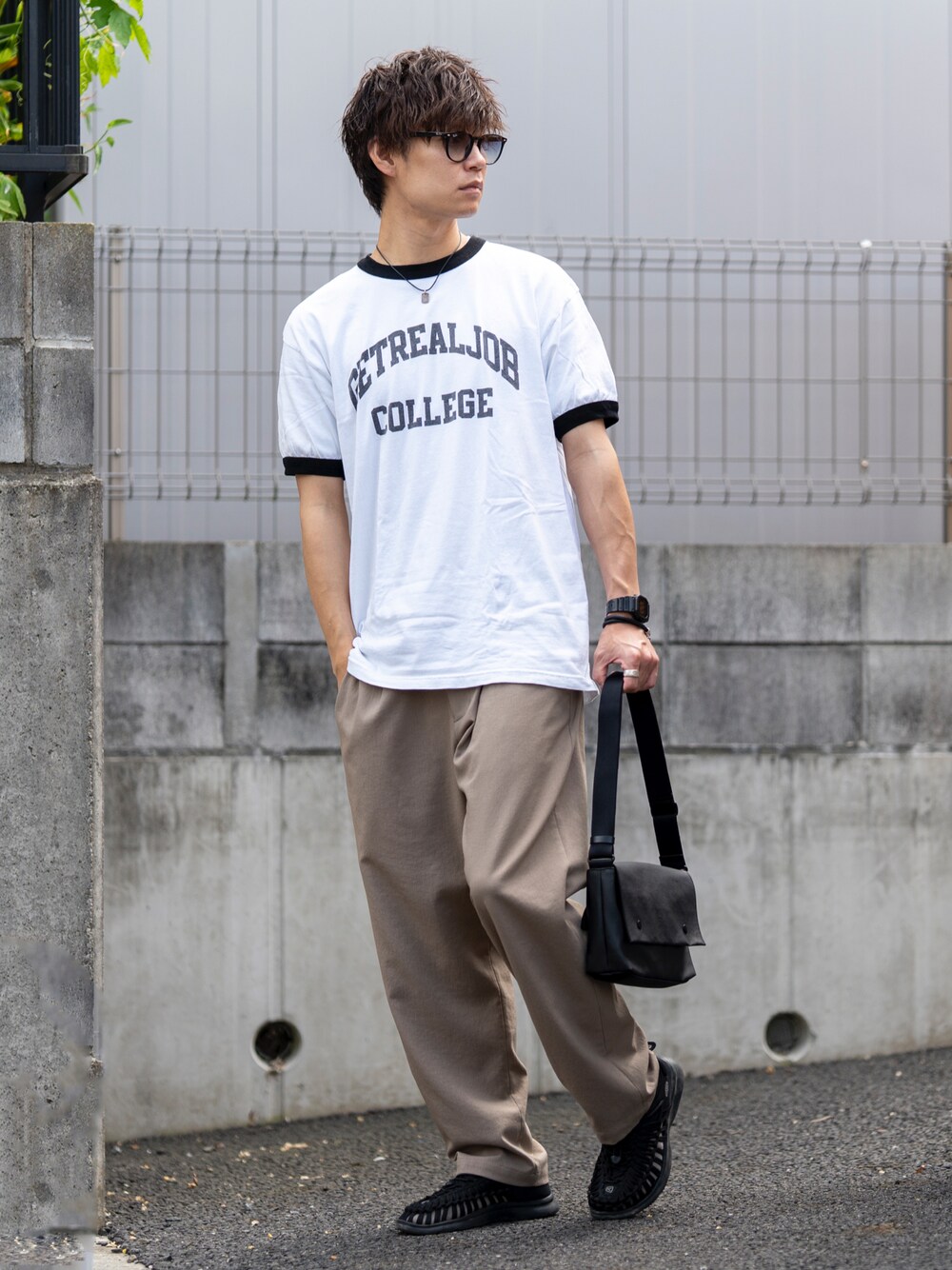 ホワイト系のTシャツ/カットソー、ベージュ系のスラックス、ブラック系のサンダルを着用したメンズの夏コーディネートの1枚目の写真