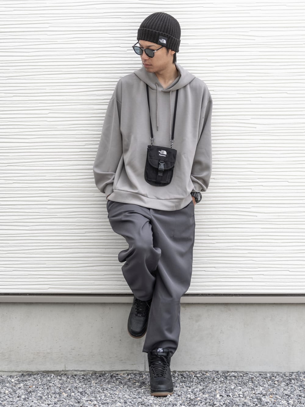 ブラック系のショルダーバッグ、グレー系のパーカー、グレー系のパンツを着用したメンズの秋コーディネートの1枚目の写真