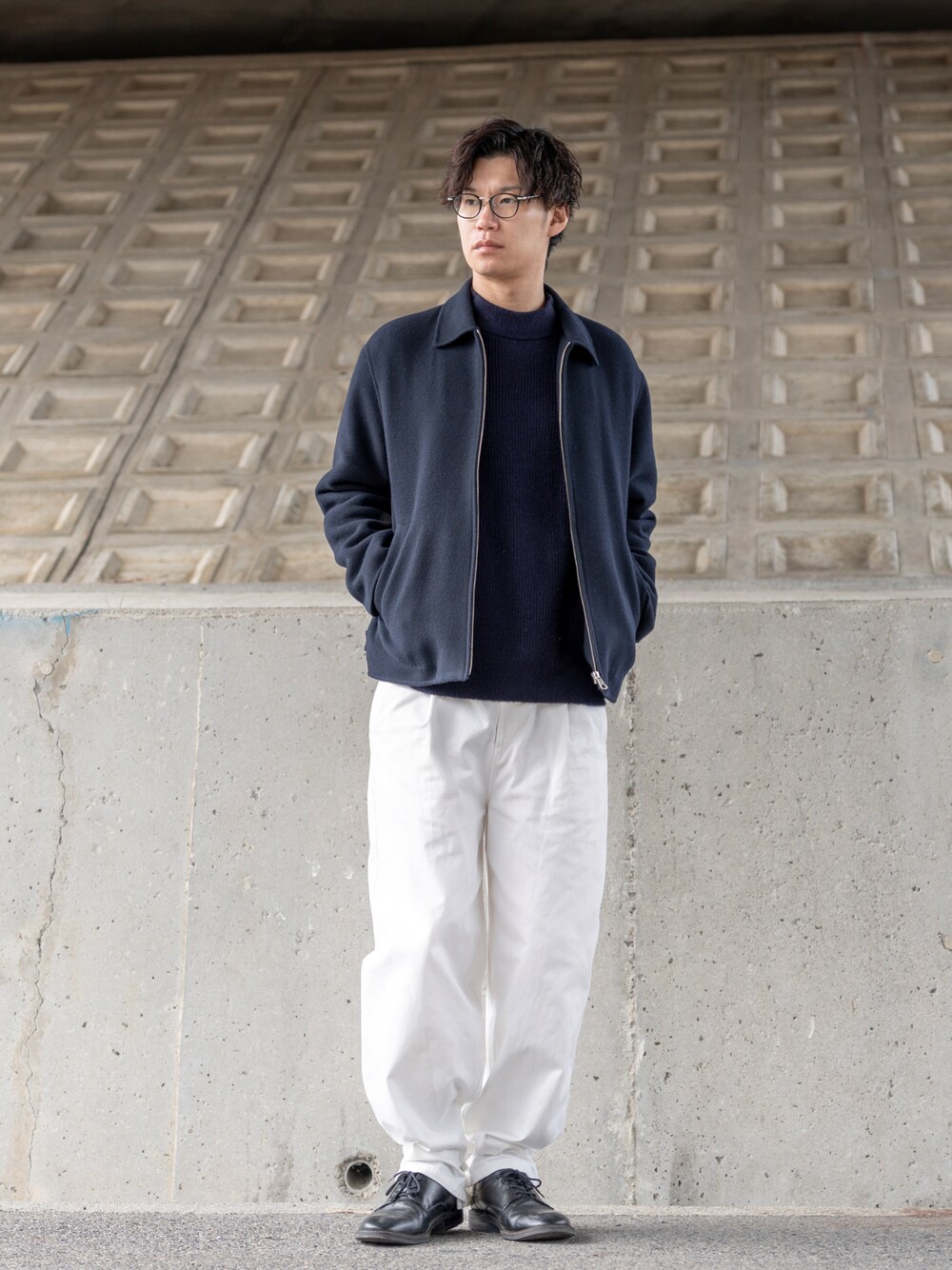 ブルー系のブルゾン、ブルー系のニット/セーター、ホワイト系のチノパンツを着用したメンズの冬コーディネートの1枚目の写真