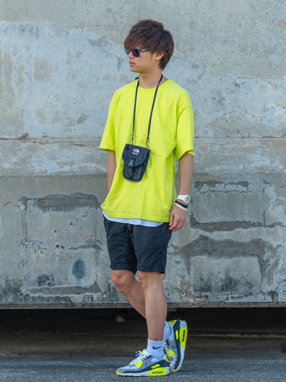 ブラック系のショルダーバッグ、イエロー系のTシャツ/カットソー、ホワイト系のタンクトップを着用したメンズの夏コーディネートの1枚目の写真