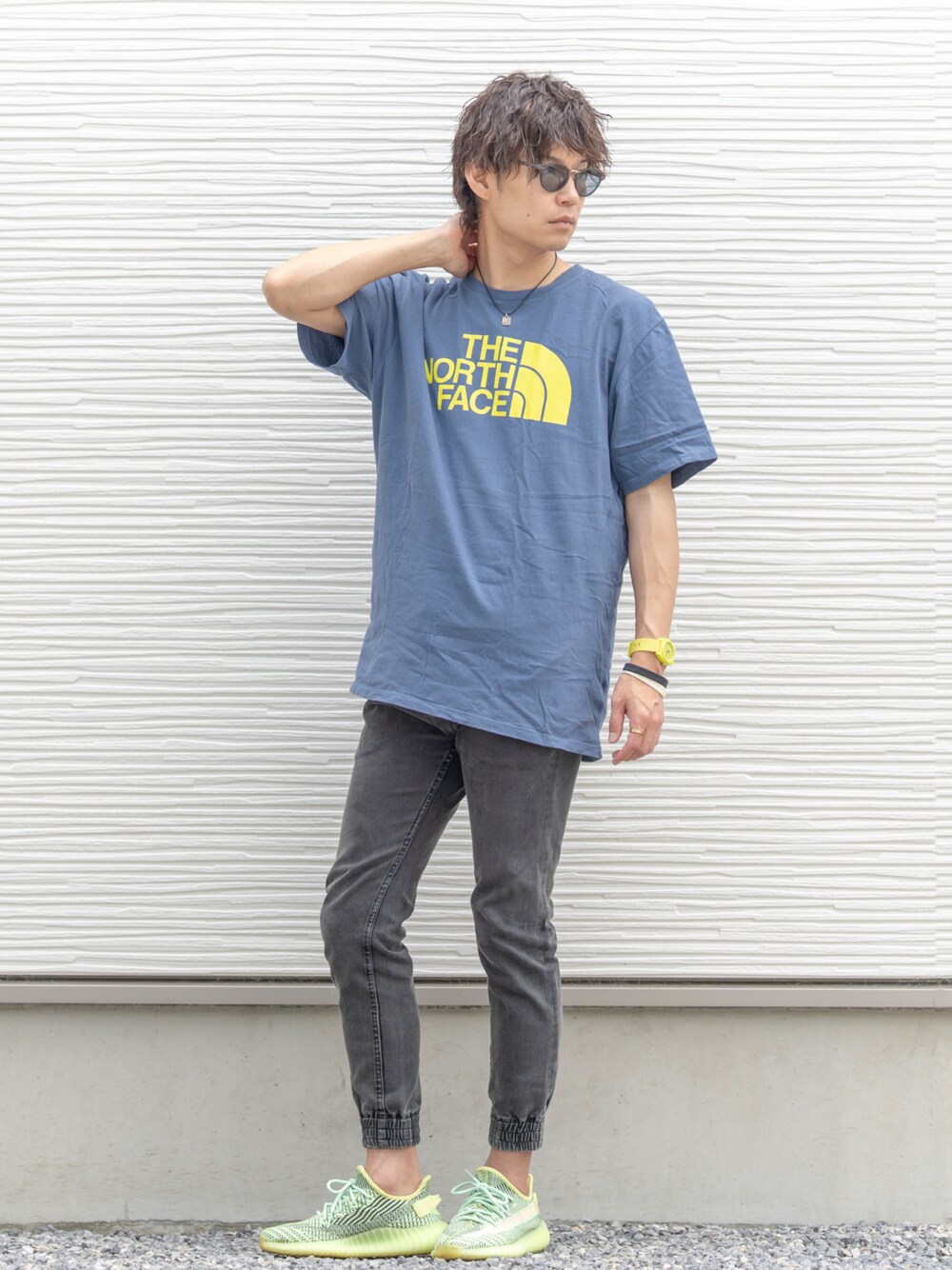 ブルー系のTシャツ/カットソー、ブラック系のデニムパンツ、グリーン系のスニーカーを着用したメンズの夏コーディネートの1枚目の写真