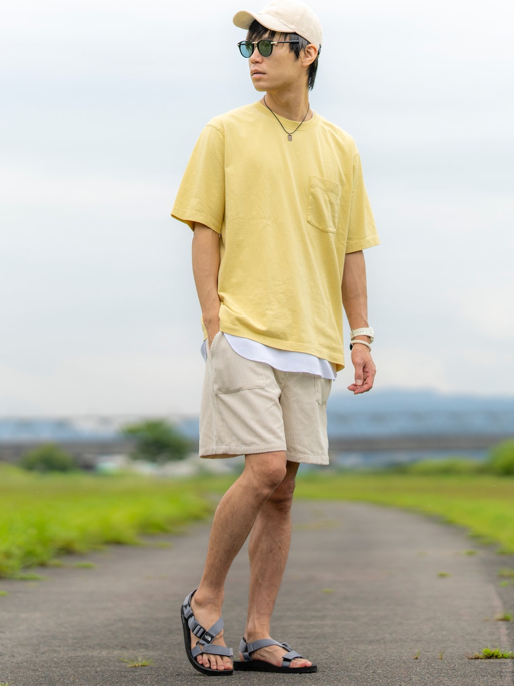 イエロー系のTシャツ/カットソー、ホワイト系のタンクトップ、ベージュ系のパンツを着用したメンズの夏コーディネートの1枚目の写真