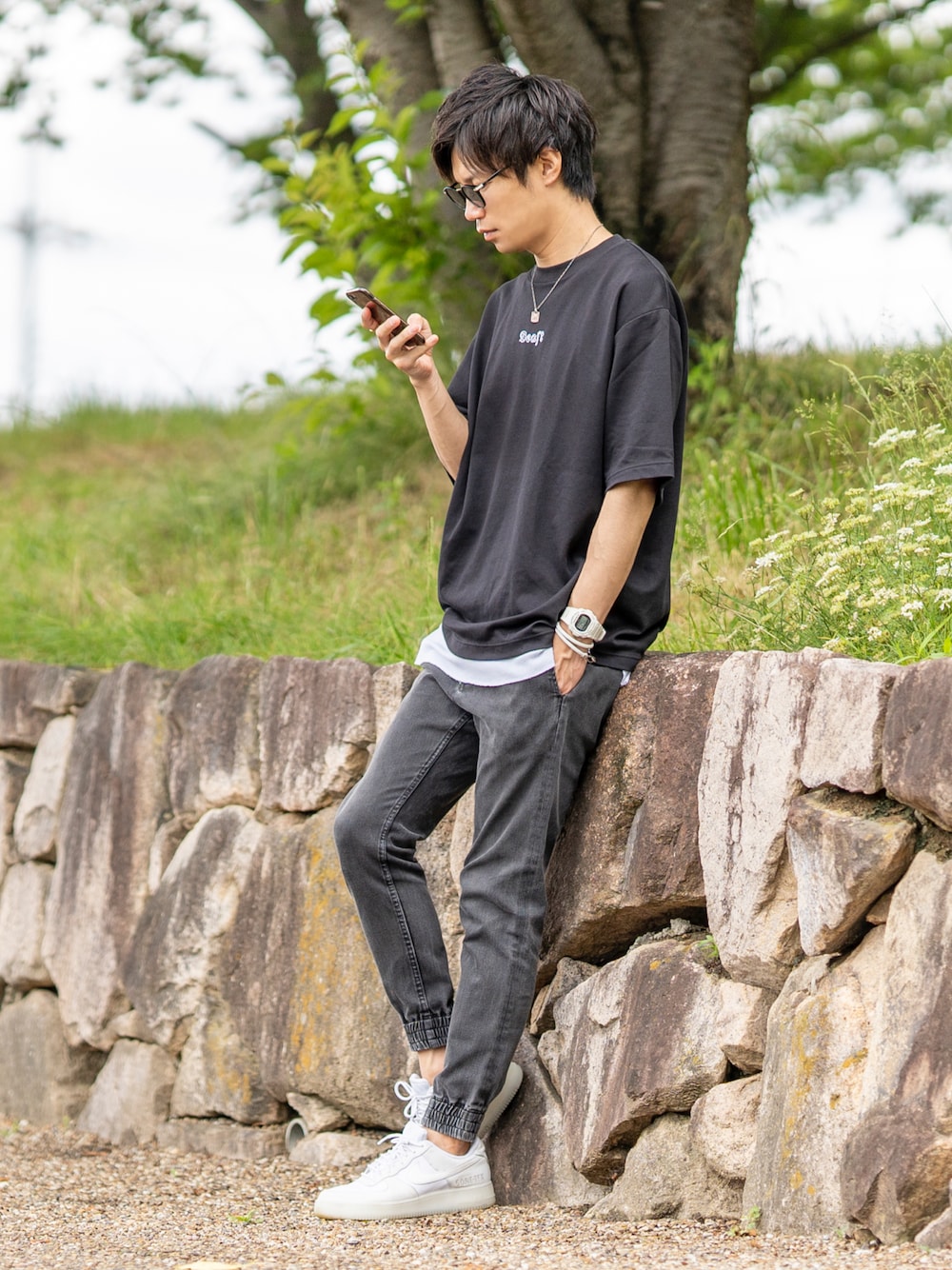 ブラック系のTシャツ/カットソー、ホワイト系のタンクトップ、ブラック系のデニムパンツを着用したメンズの夏コーディネートの1枚目の写真