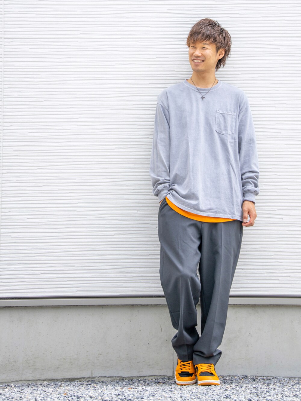 グレー系のTシャツ/カットソー、オレンジ系のTシャツ/カットソー、グレー系のその他パンツを着用したメンズの秋コーディネートの1枚目の写真
