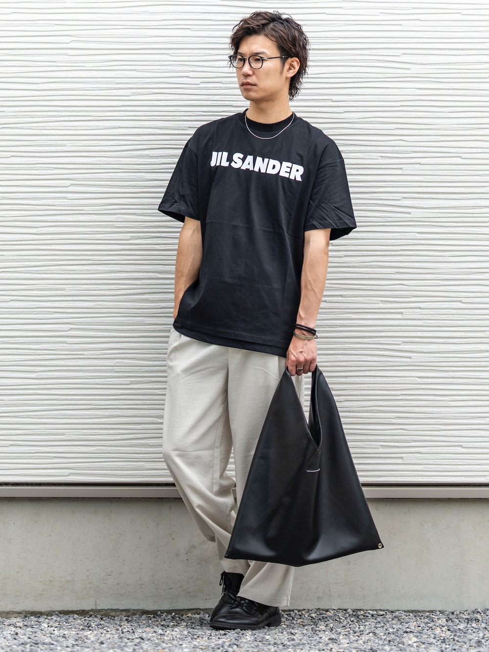 ブラック系のTシャツ/カットソー、ホワイト系のスラックス、ブラック系のトートバッグを着用したメンズの夏コーディネートの1枚目の写真