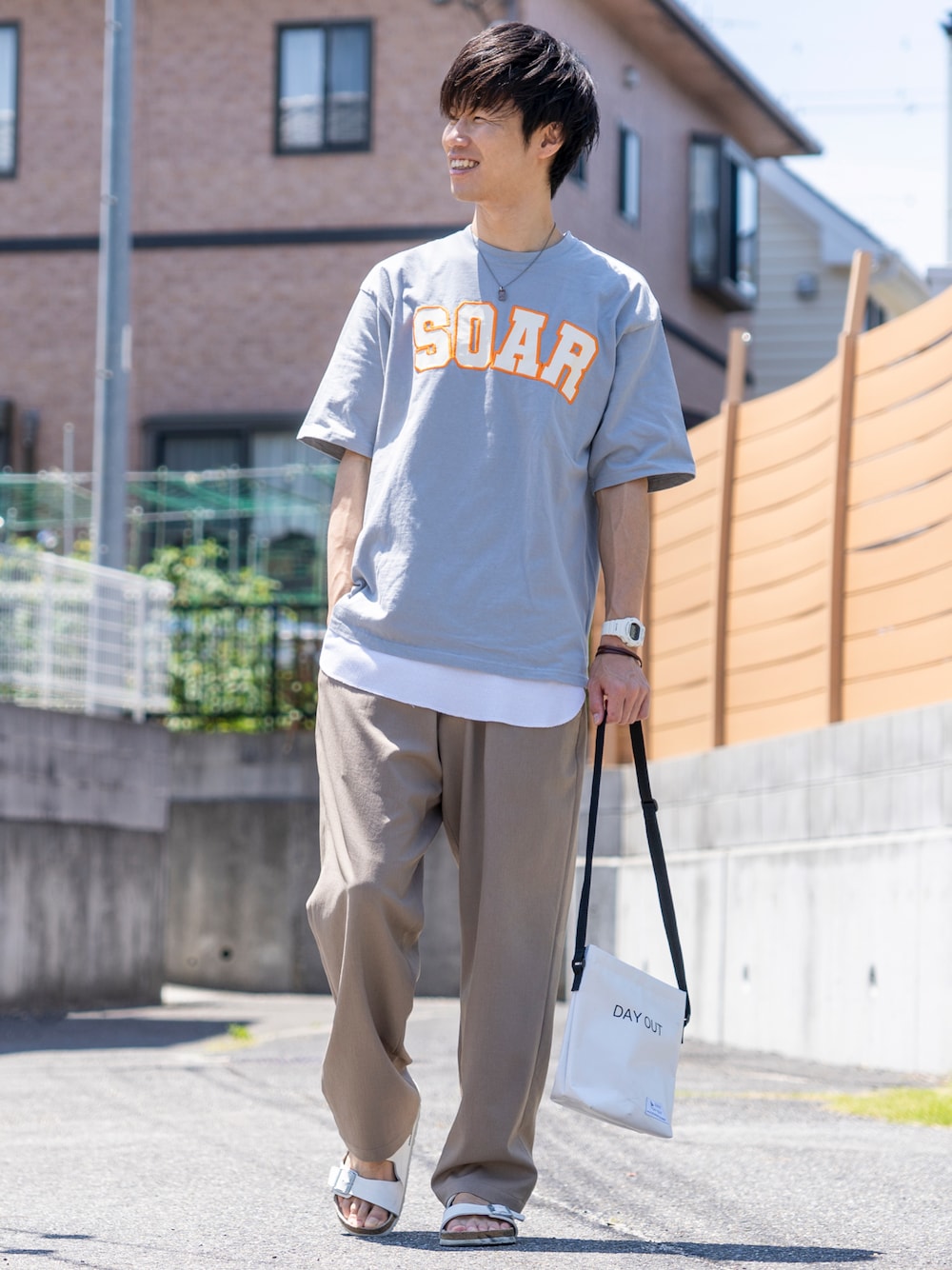 ブルー系のTシャツ/カットソー、ホワイト系のタンクトップ、ベージュ系のスラックスを着用したメンズの夏コーディネートの1枚目の写真
