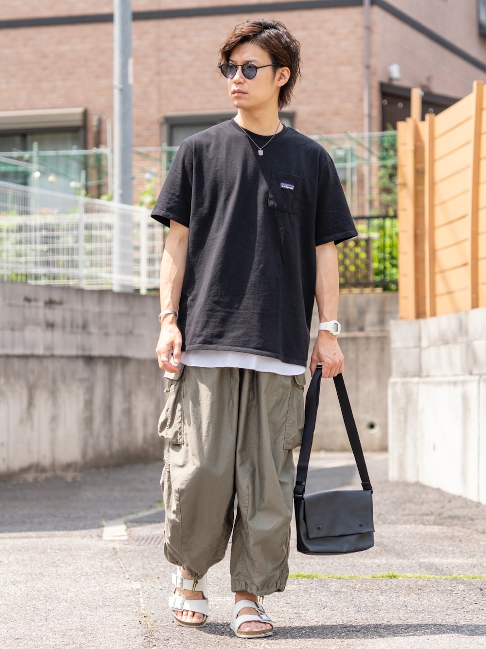 ブラック系のTシャツ/カットソー、ホワイト系のタンクトップ、グリーン系のカーゴパンツを着用したメンズの夏コーディネートの1枚目の写真