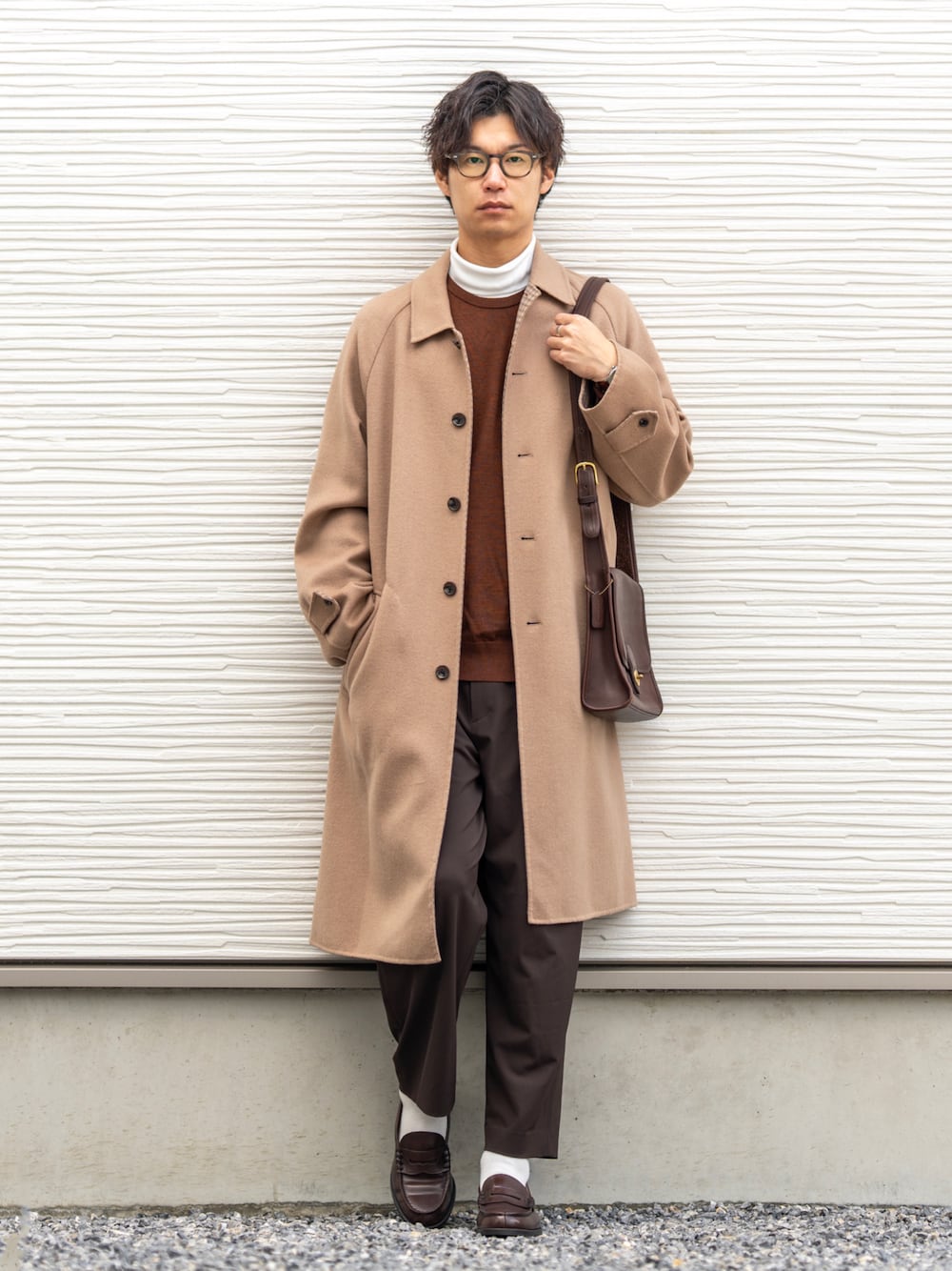 ベージュ系のステンカラーコート、ホワイト系のTシャツ/カットソー、ブラウン系のニット/セーターを着用したメンズの冬コーディネートの1枚目の写真