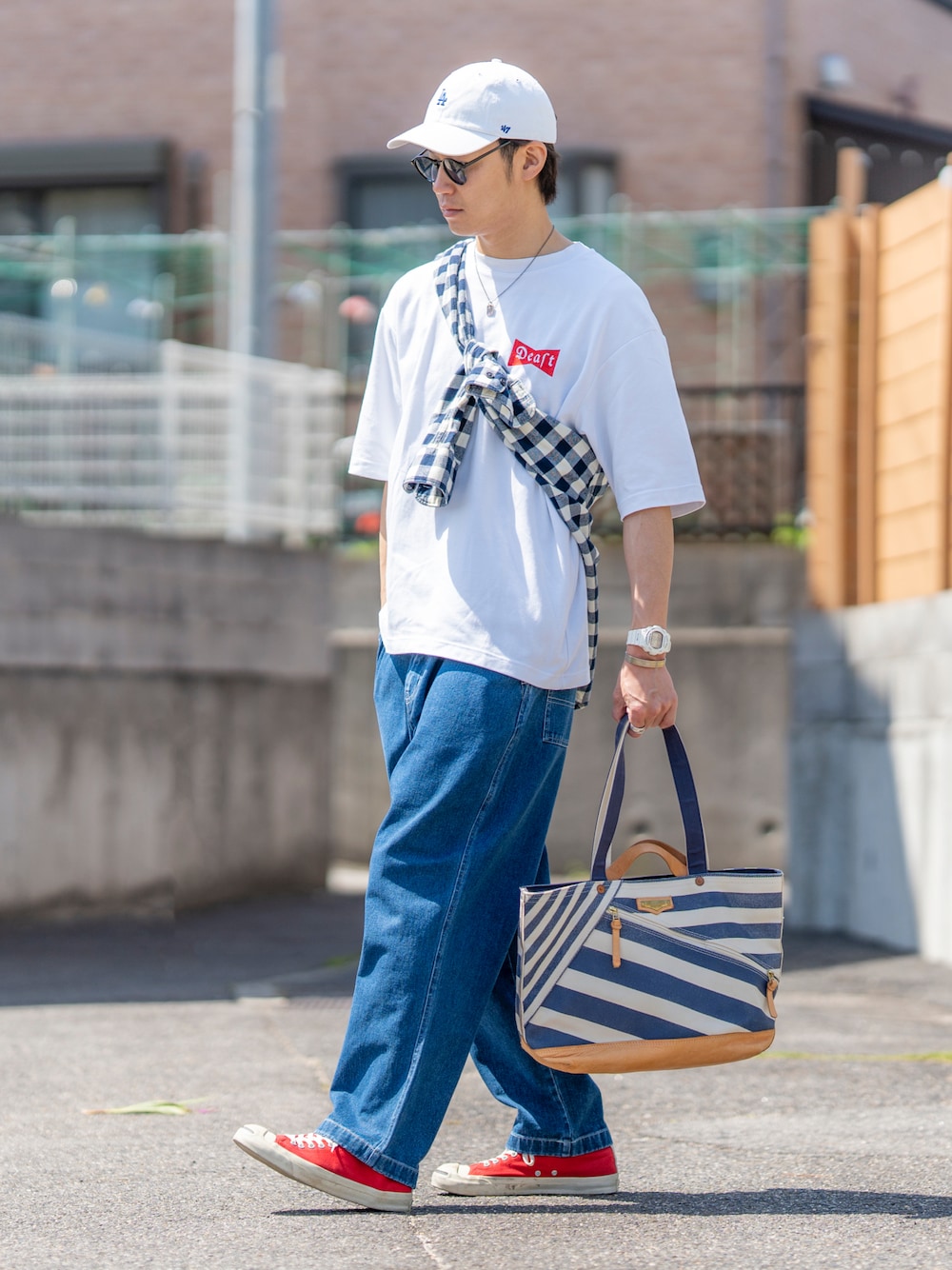 ホワイト系のTシャツ/カットソー、ブルー系のデニムパンツ、レッド系のスニーカーを着用したメンズの春コーディネートの1枚目の写真