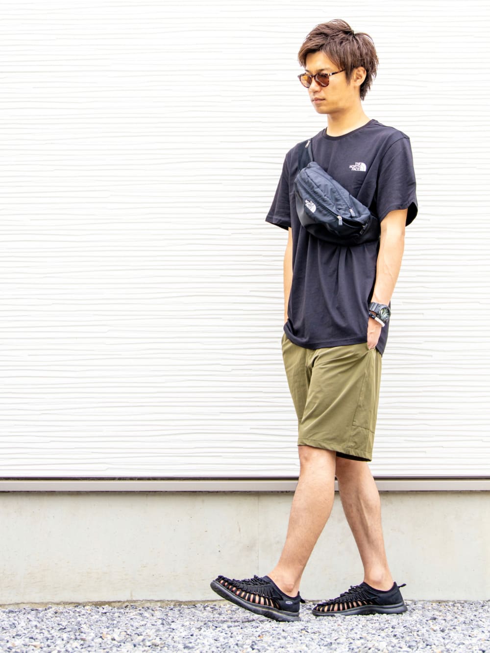 ブラック系のボディバッグ/ウエストポーチ、ブラック系のTシャツ/カットソー、グリーン系のその他パンツを着用したメンズの夏コーディネートの1枚目の写真