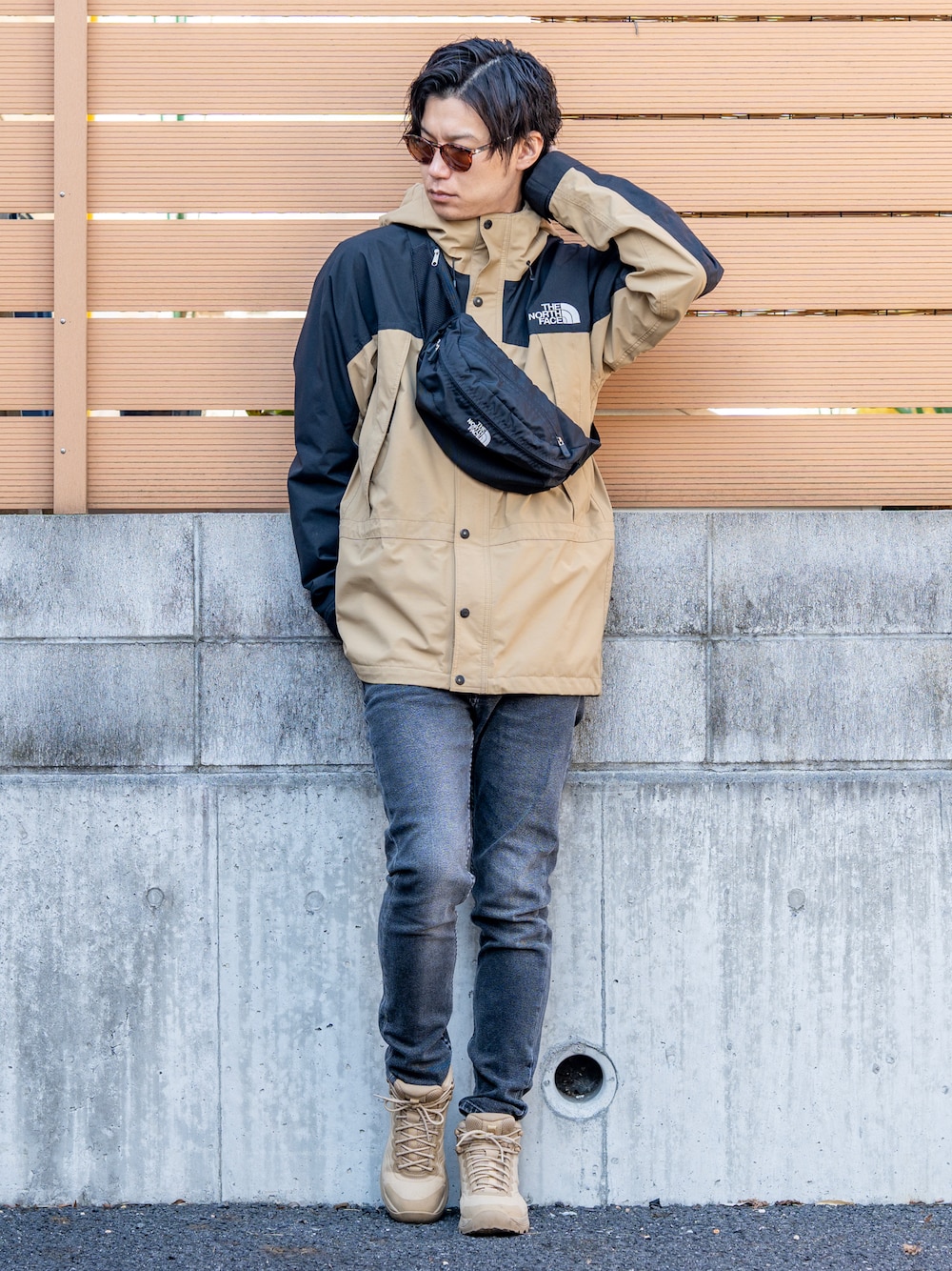 ベージュ系のマウンテンパーカー、グレー系のデニムパンツ、ベージュ系のブーツを着用したメンズの冬コーディネートの1枚目の写真