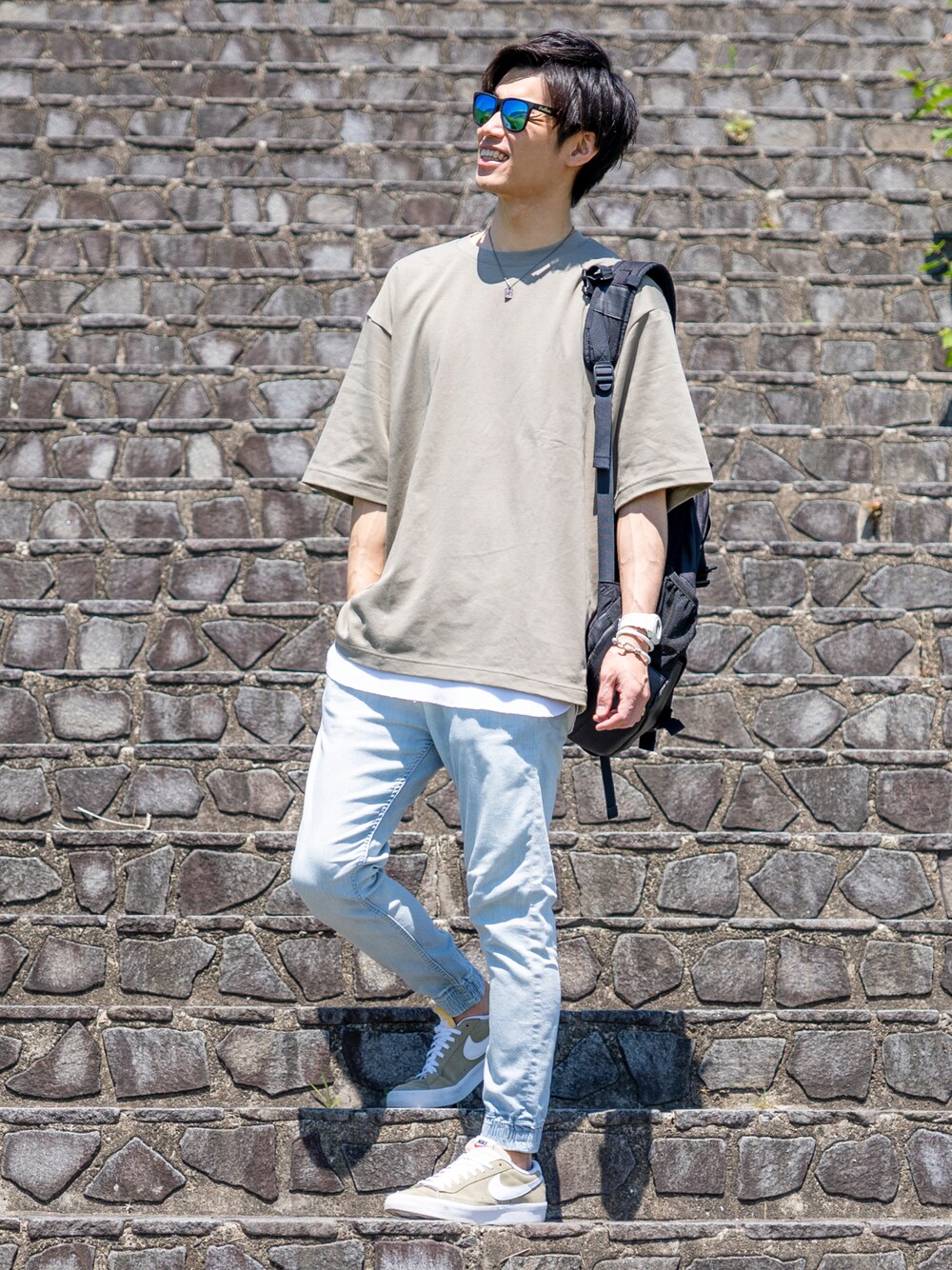 グリーン系のTシャツ/カットソー、ブラック系のバックパック/リュック、ホワイト系のタンクトップを着用したメンズの夏コーディネートの1枚目の写真