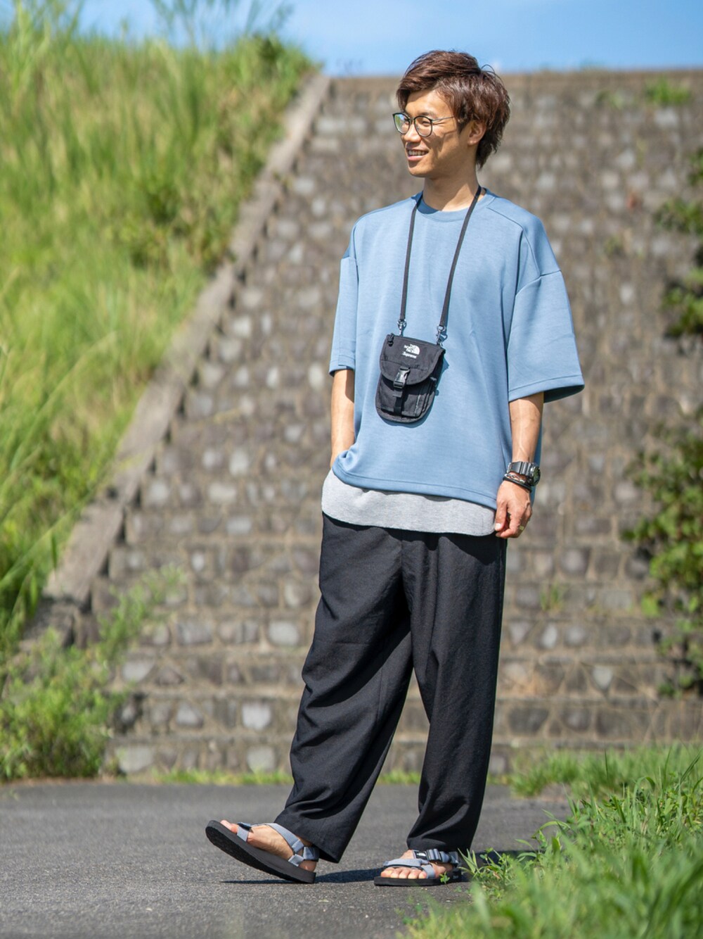 ブルー系のTシャツ/カットソー、ブラック系のショルダーバッグ、グレー系のタンクトップを着用したメンズの夏コーディネートの1枚目の写真