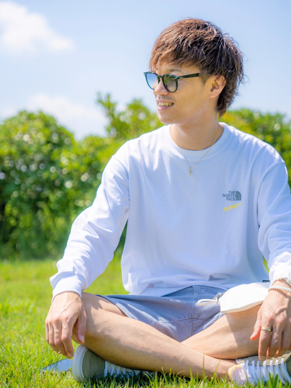 ホワイト系のTシャツ/カットソー、ブルー系のその他パンツ、ホワイト系のクラッチバッグを着用したメンズの秋コーディネートの1枚目の写真