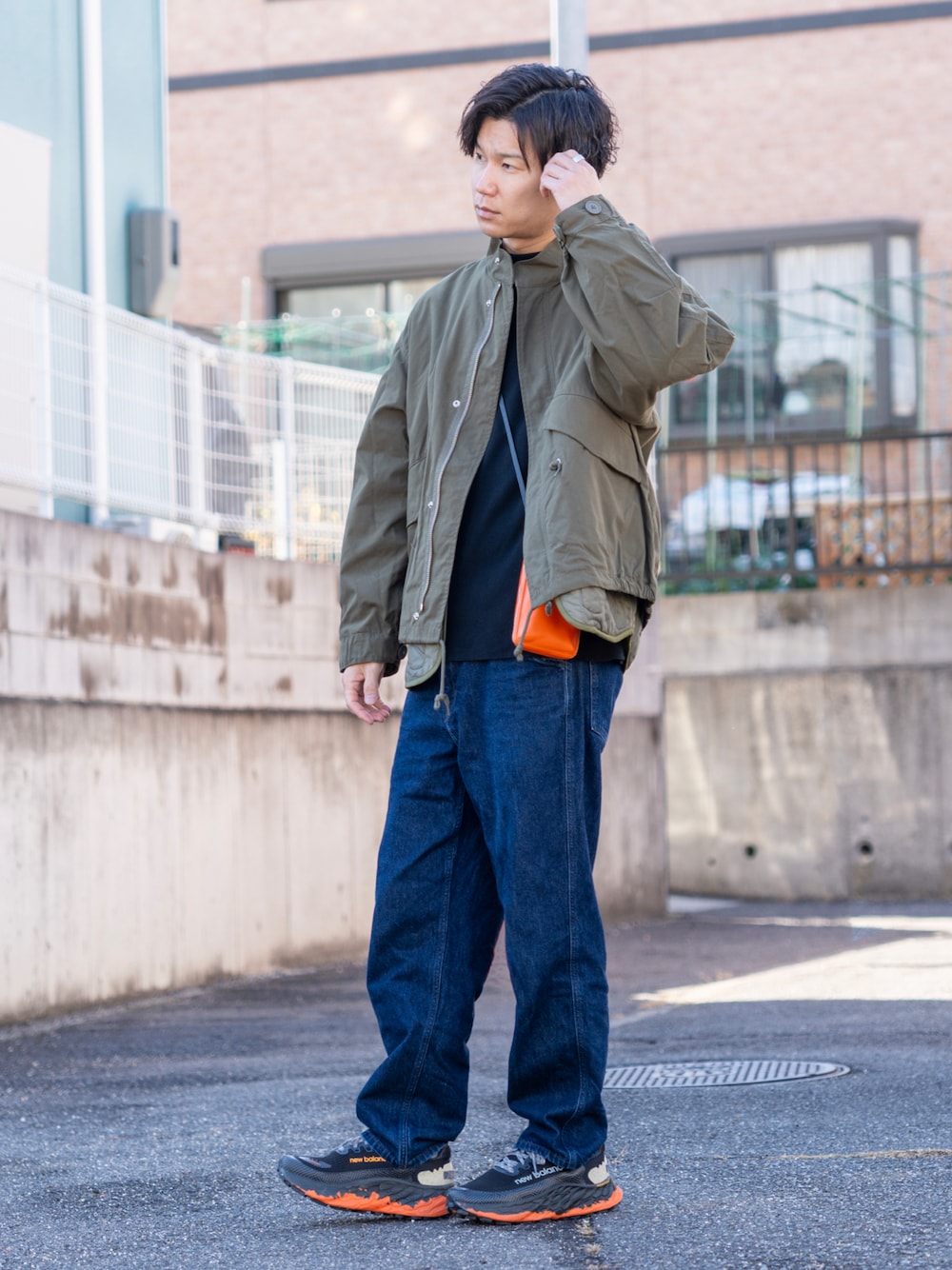 グリーン系のモッズコート、ブラック系のスウェット、ブルー系のデニムパンツを着用したメンズの冬コーディネートの1枚目の写真