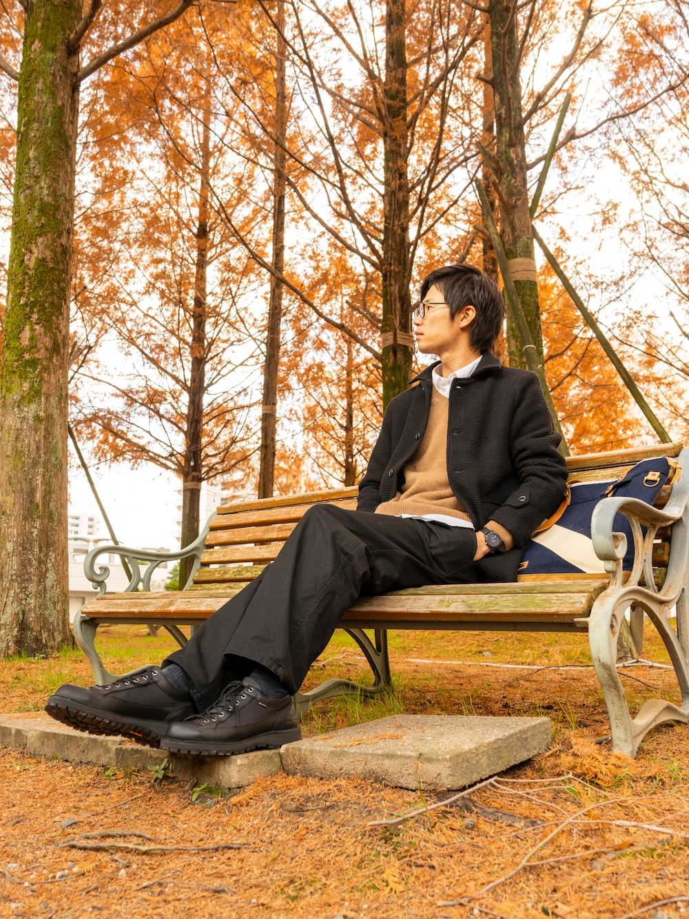 ブラック系のピーコート、グリーン系のニット/セーター、ホワイト系のトップスを着用したメンズの冬コーディネートの1枚目の写真