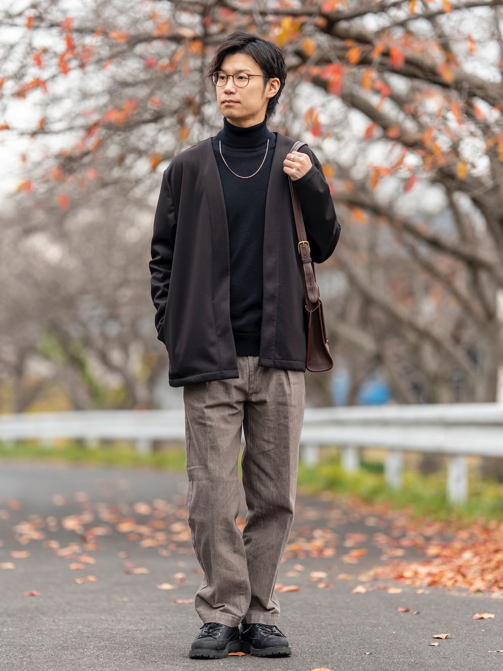 ブラック系のカーディガン/ボレロ、ブラック系のニット/セーター、ブラウン系のデニムパンツを着用したメンズの冬コーディネートの1枚目の写真